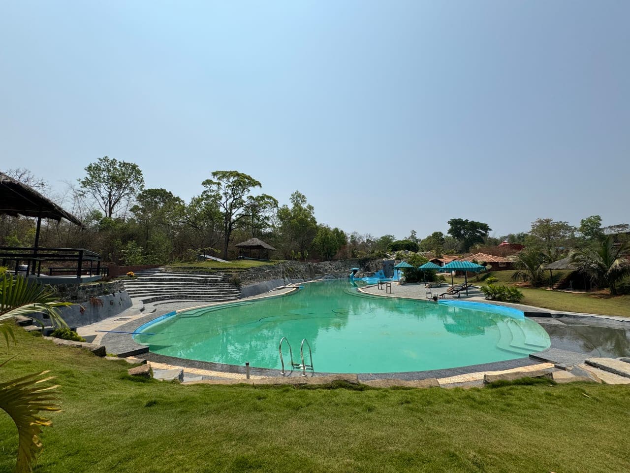 Resort pool area with lush gardens and resort buildings